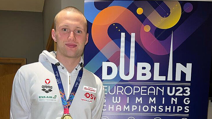 Bucher mit Goldmedaille vor Plakat EM Dublin